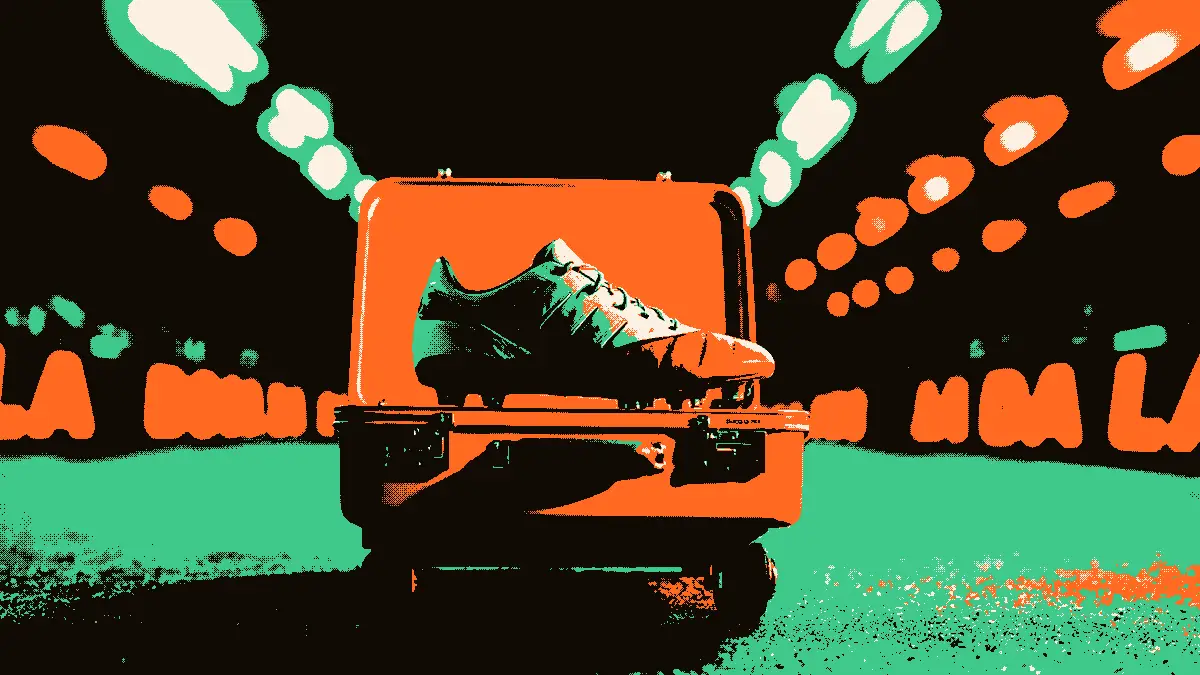 Une scène de transfert symbolisée par une valise ouverte contenant un crampon, posée sur un chariot à bagages, dans un couloir de stade illuminé par des projecteurs flous à l'arrière-plan.