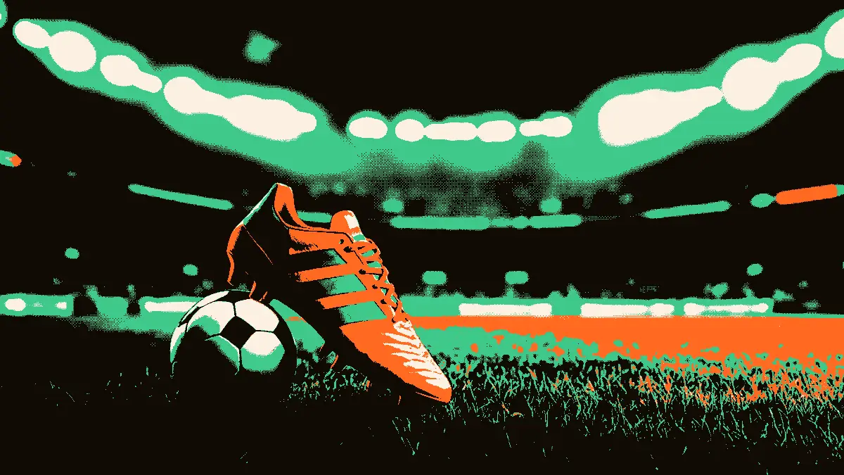 Une paire de crampos isolée sur l'herbe avec un ballon derrière et les tribunes vides d'un stade en arrière-plan, évoquant la veille d'une rencontre continentale.