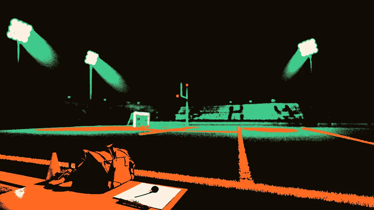 Un terrain de football illuminé par des projecteurs, avec un banc de touche où reposent un sifflet et une planchette, une valise de sport ouverte à côté de crampons et de plots, et des gradins en arrière-plan.