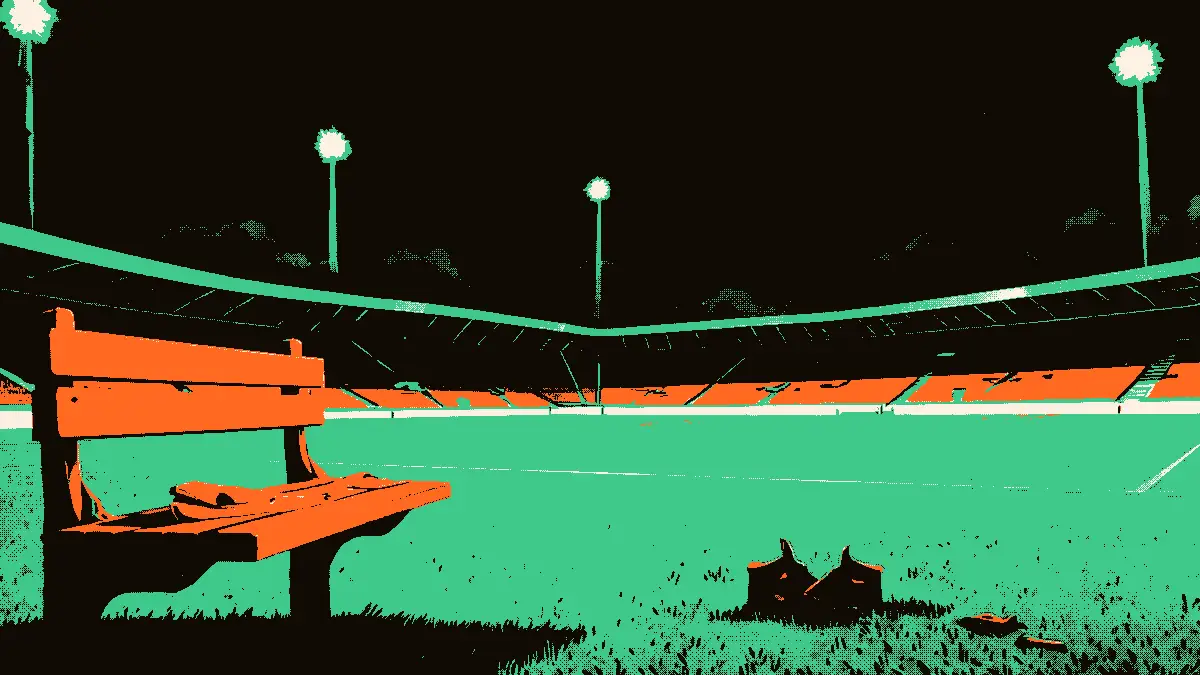 Vue d'un terrain de football au crépuscule sous la lumière des projecteurs, avec un banc vide au premier plan où repose un brassard de capitaine plié, accompagné d'un sifflet et d'une paire de crampons posés sur l'herbe.