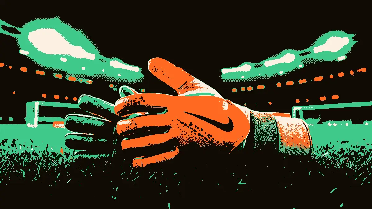 Une scène de football montrant deux paires de gants de gardien posées sur l'herbe au premier plan, symbolisant un gardien titulaire et son remplaçant, avec en arrière-plan des filets de but et des projecteurs de stade illuminant la pelouse.