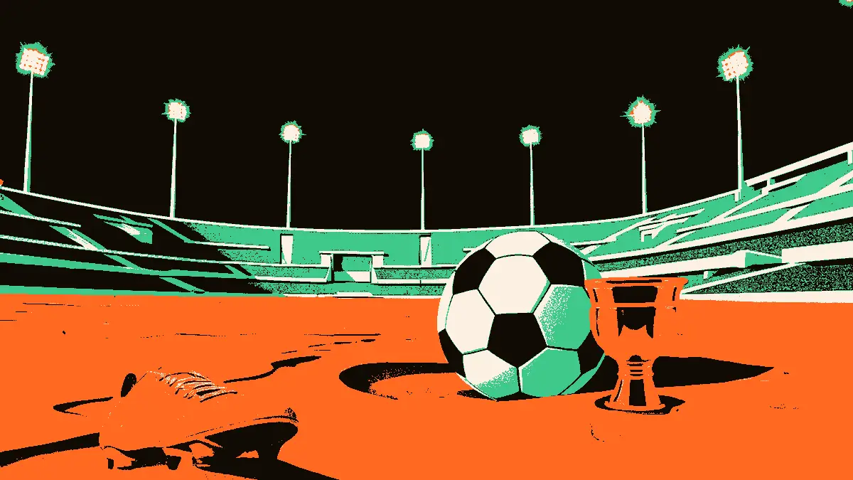 Un ballon de football à moitié enfoui dans le sable, accompagné d'un crampon et d'une petite coupe dorée, devant les gradins vides d'un stade en béton illuminé par de hauts projecteurs dans une atmosphère désertique.
