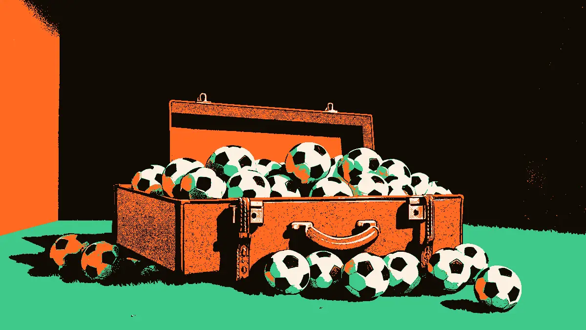 Une valise en cuir ouverte débordant de nombreux petits ballons de football qui s'éparpillent sur la pelouse près de l'entrée du tunnel d'un stade.