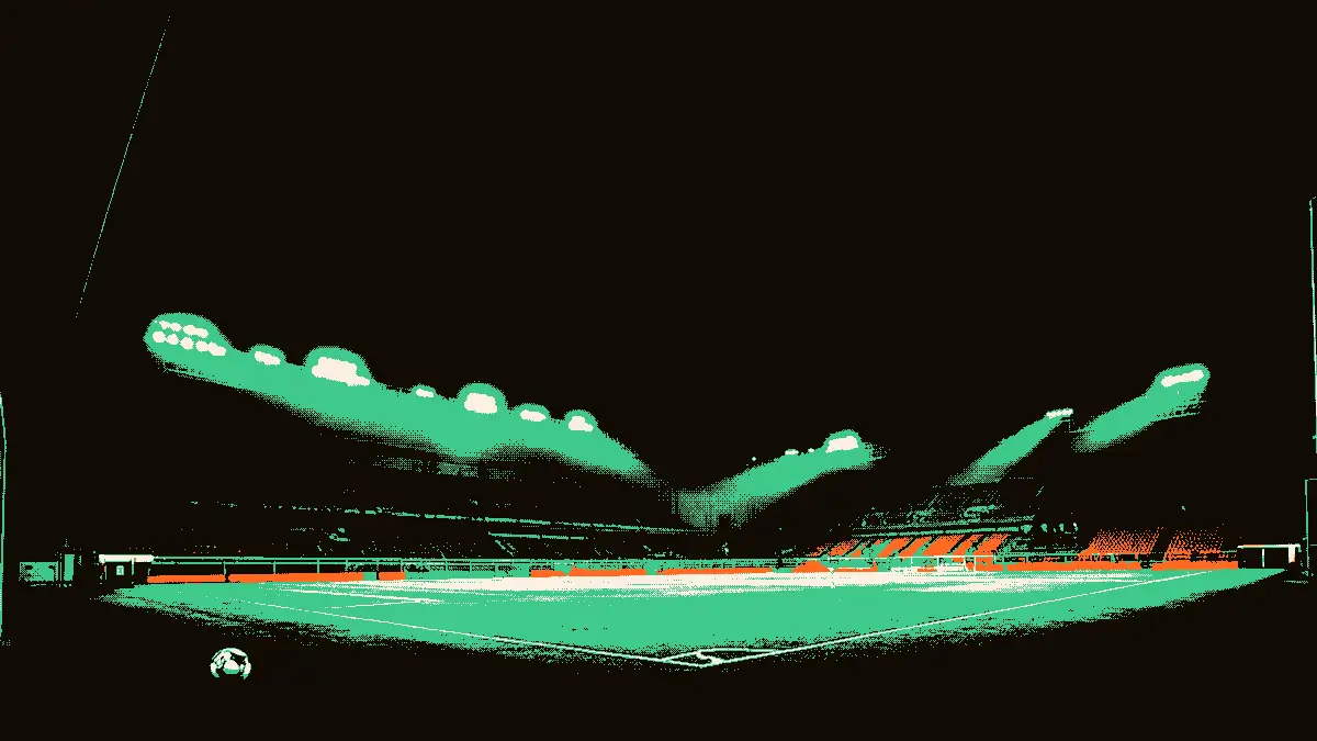 Un terrain de football vide vu depuis le tunnel d'entrée, avec un ballon oublié près du cercle central et des projecteurs éclairant des gradins déserts, évoquant une sélection en recomposition.
